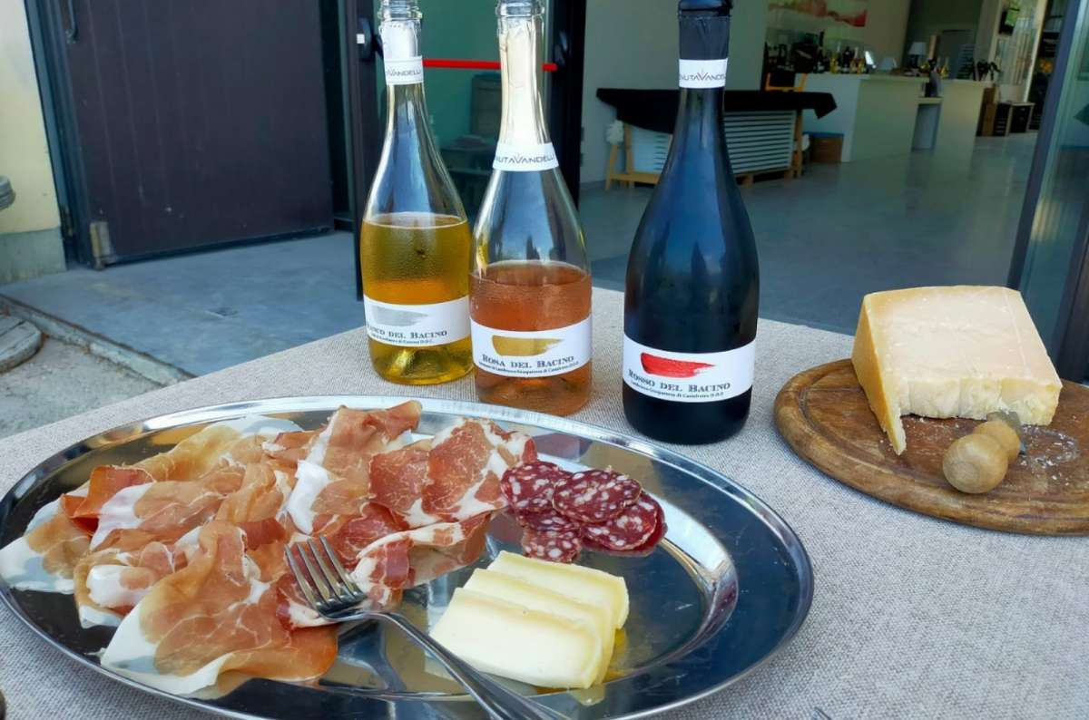 Italian charcuterie platter with prosciutto, salami, and cheese, served alongside three bottles of wine, Facts about Italian food