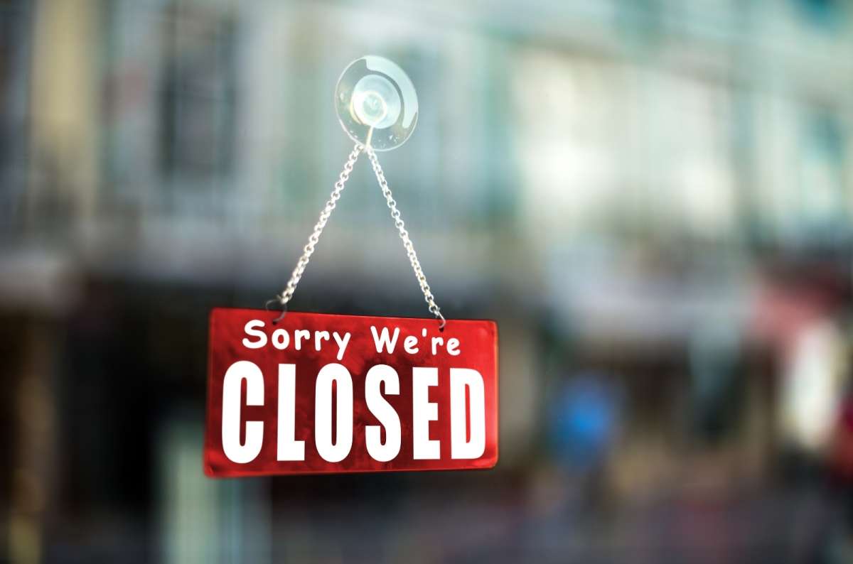 a photo of a red “closed” sign on the door of an establishment