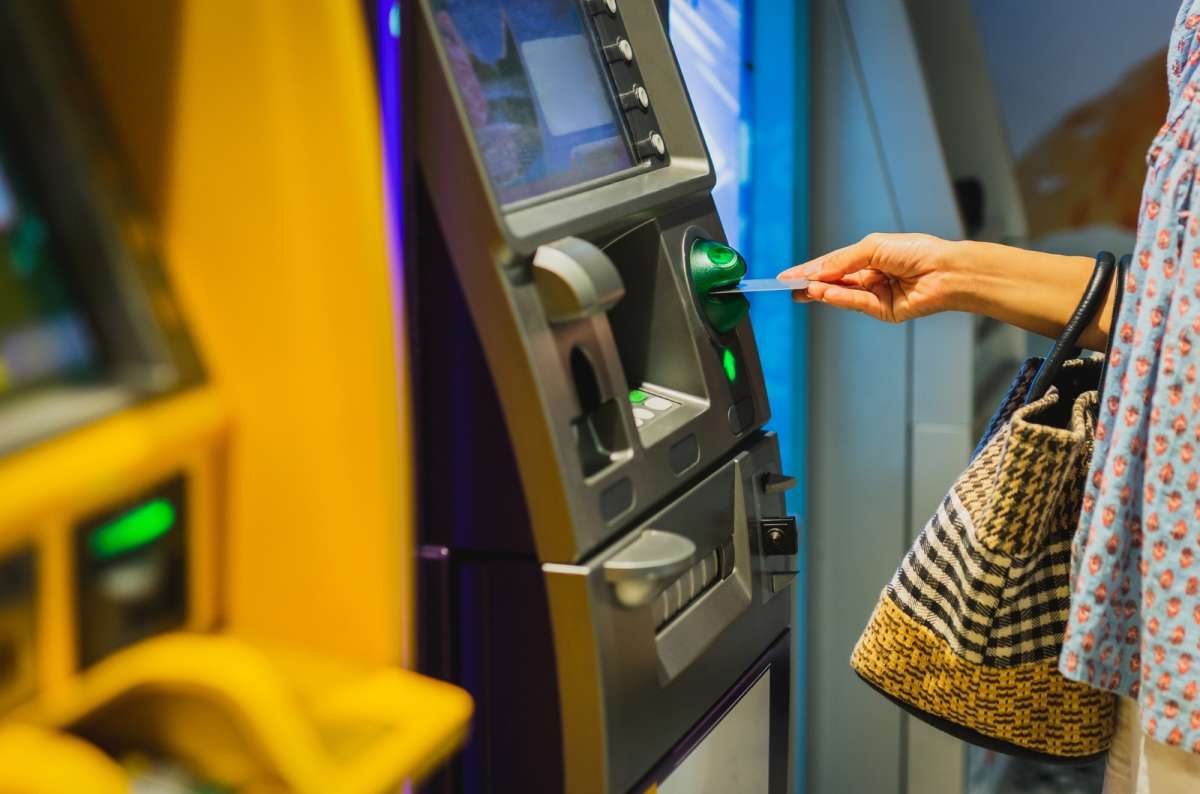 A photo of a woman taking money out of an ATM