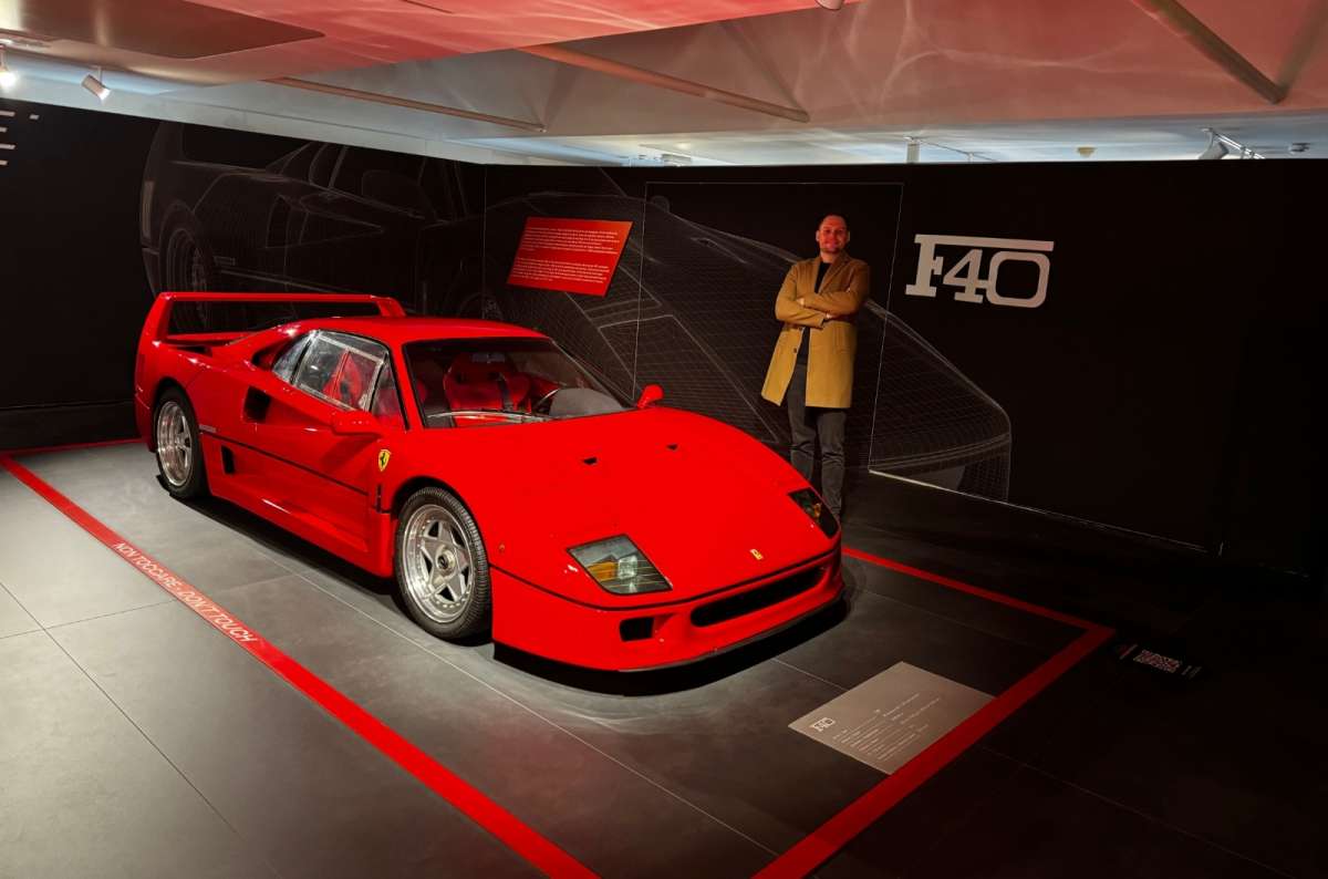 A tourist posing behind a red Ferrari ath the Maranello Ferrari Museum