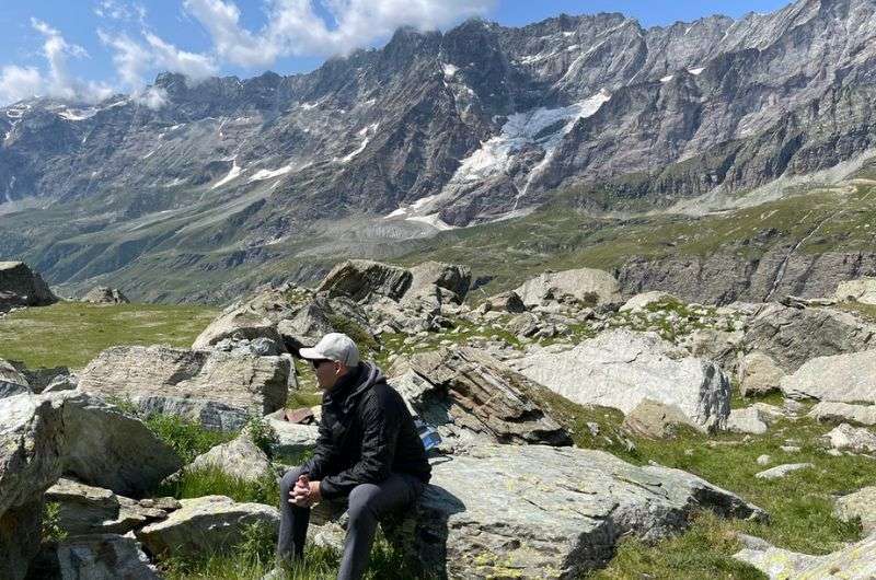 A tourist sitting on a rock in the valley under the Matterhorn, Italy, photo by Next Level of Travel