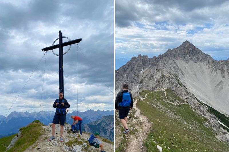 Man at a summit cross overlooking the Alps and a rugged mountain ridge with a winding trail, Seefelder Spitze hike, Austria, photo by Next level of travel