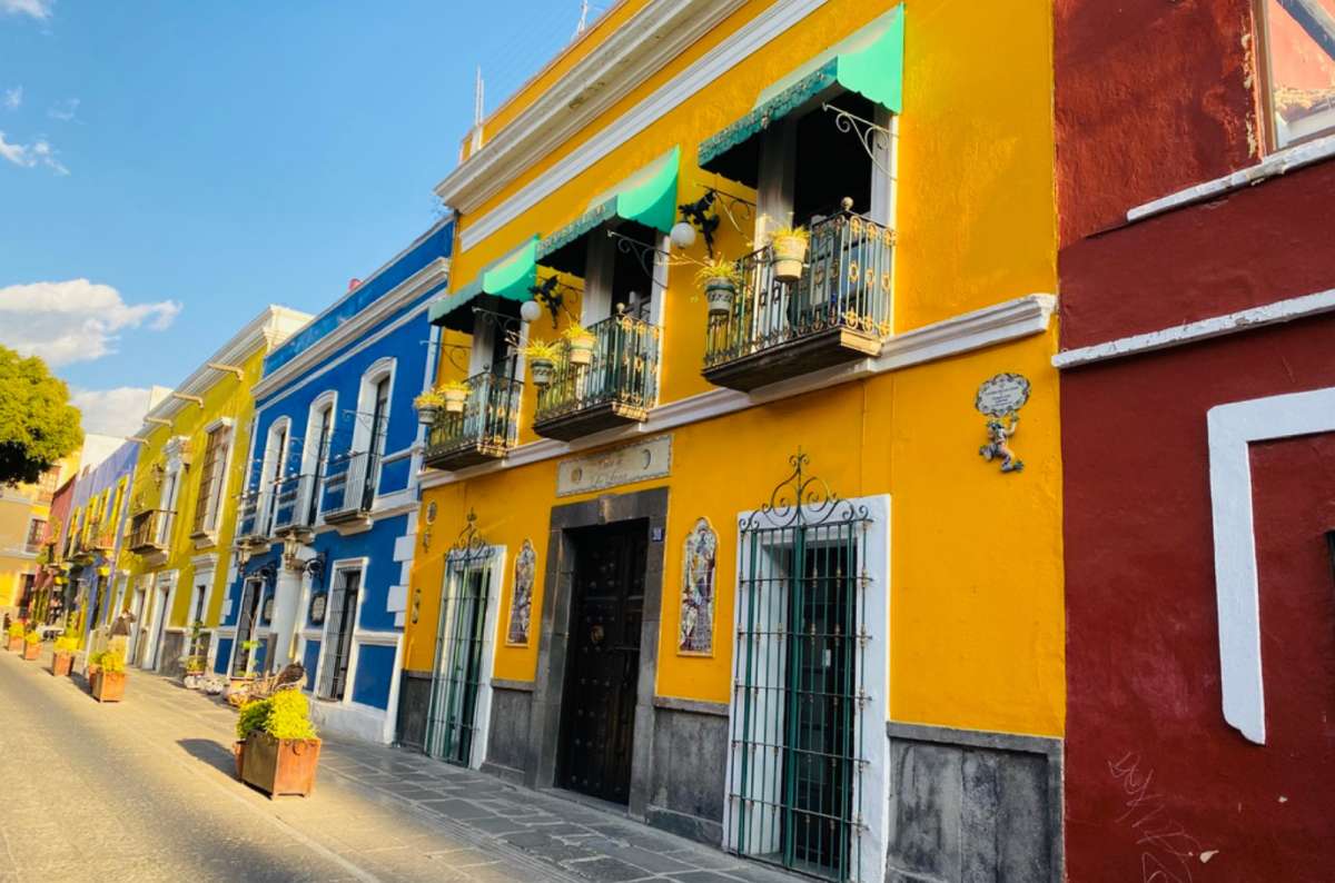 a photo of a street in pouebla showing the colorful houses decorating the narrow street, Mexico, photo by Next Level of Travel