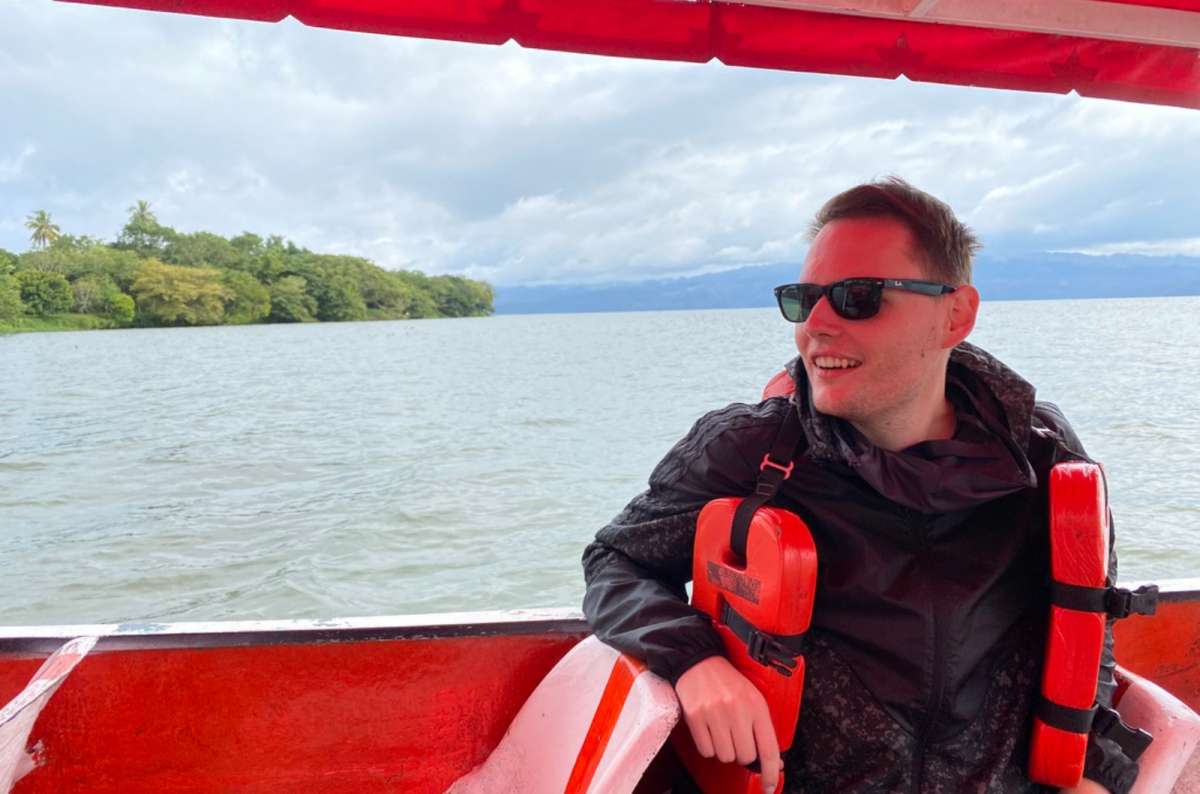 a tourist posing in a safety jacket on a boat cruise  at Lago Tacemaco, Mexico, photo by Next Level of Travel