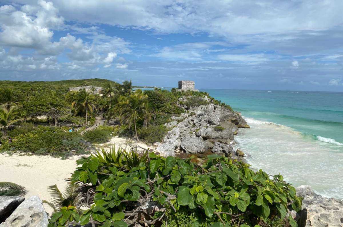 a photo of the Tulum ruins on a cliff above a Caribbean beach, Mexico, photo by Next Level of Travel