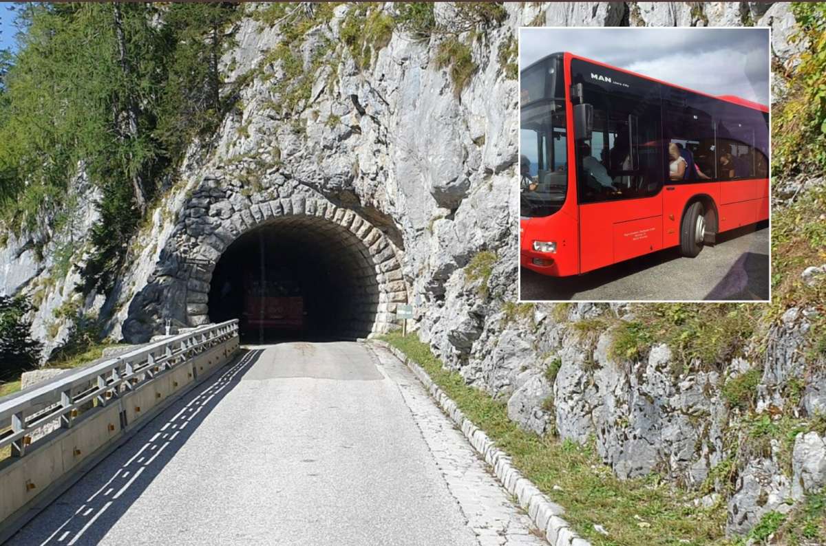 A red bus enters a narrow mountain tunnel on the way to Eagle’s Nest, Germany