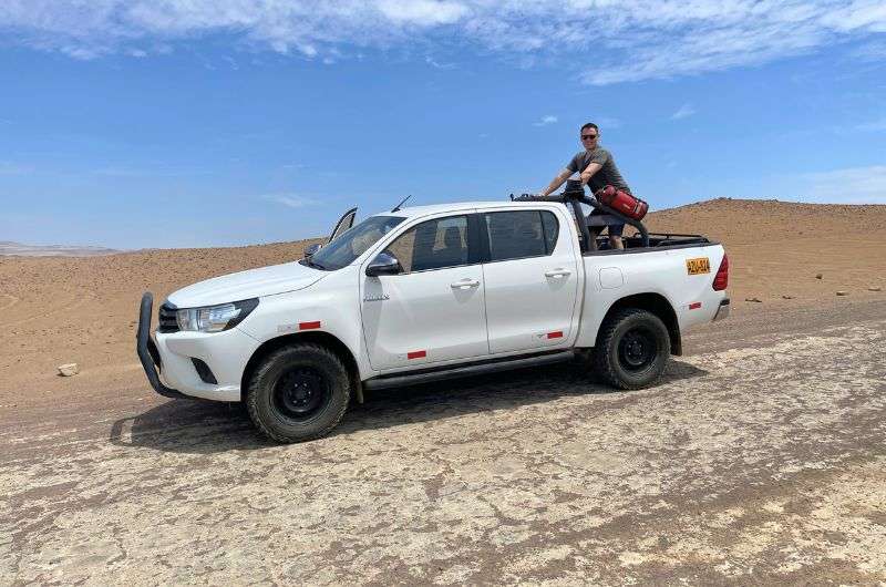tourist and a car in Paracas, Peru, photo by Next Level of Travel