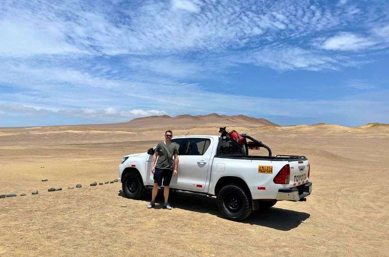 Traveler and his car in Paracas, Peru, photo by Next Level of Travel