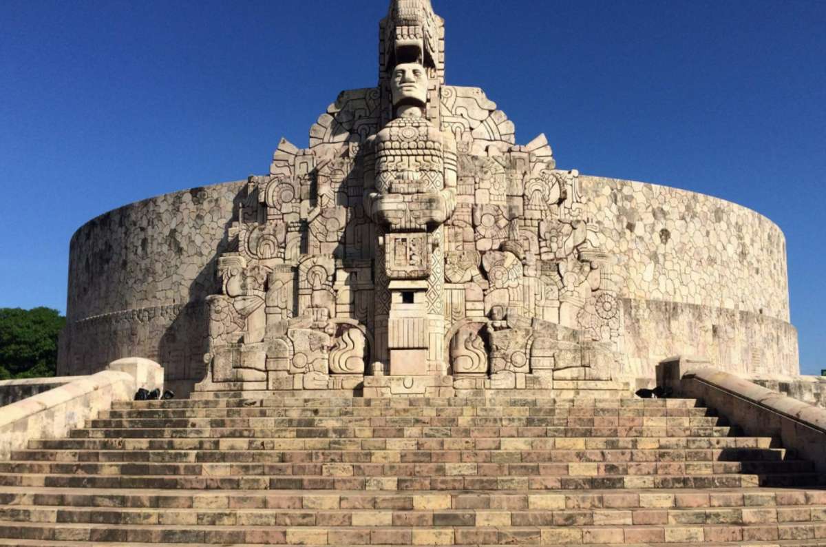 Monumento a la Patria in Mérida, Yucatán, Mexico, with carved stone reliefs, wide steps, and clear blue sky in the background 