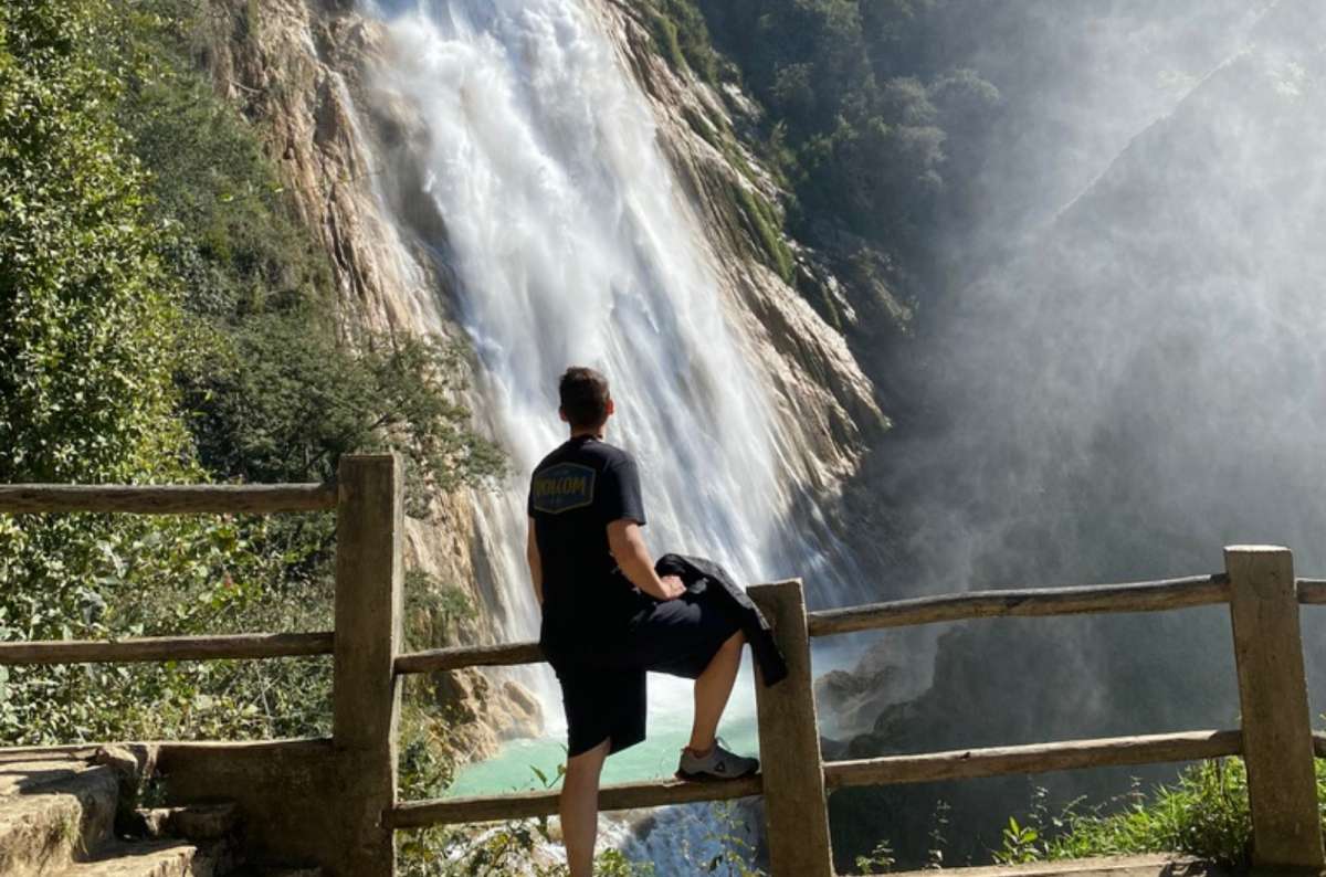 a photo of a tourist walking along the wooden boardwalk trail toward Cascada Velo de Novia, El Chiflón, Chiapas, photo by Next Level of Travel