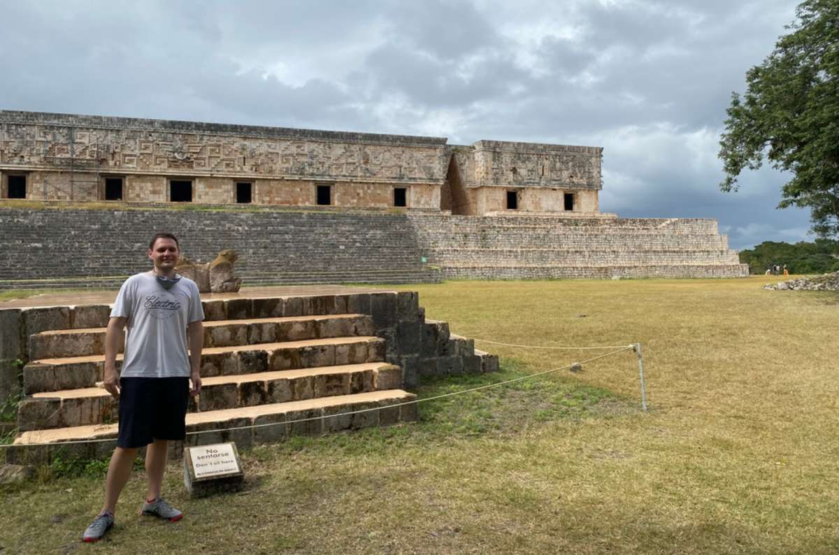 a tourist posing in front of the Mayan ruins at Chichen Itzá on the Yucatán Peninsula, Mexico, photo by Next Level of Travel
