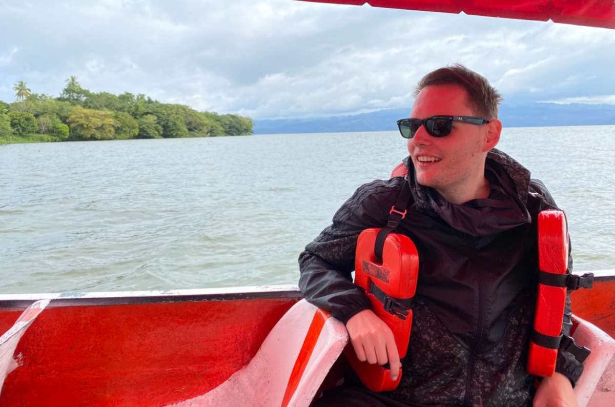 a trourist relaxing on a small boat on a lake near Veracruz, wearing a safety vest, Mexico, photo by Next Level of Travel