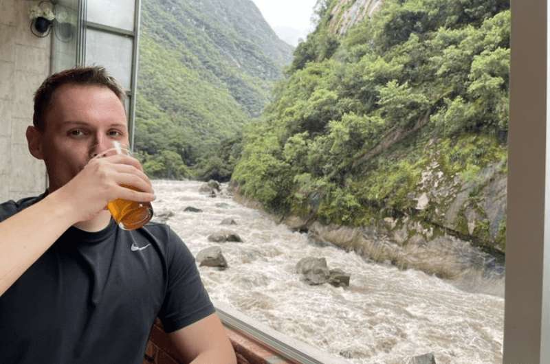 Sitting on the terrace with a view drinking beer at Chullos Restaurant in Machu Picchu
