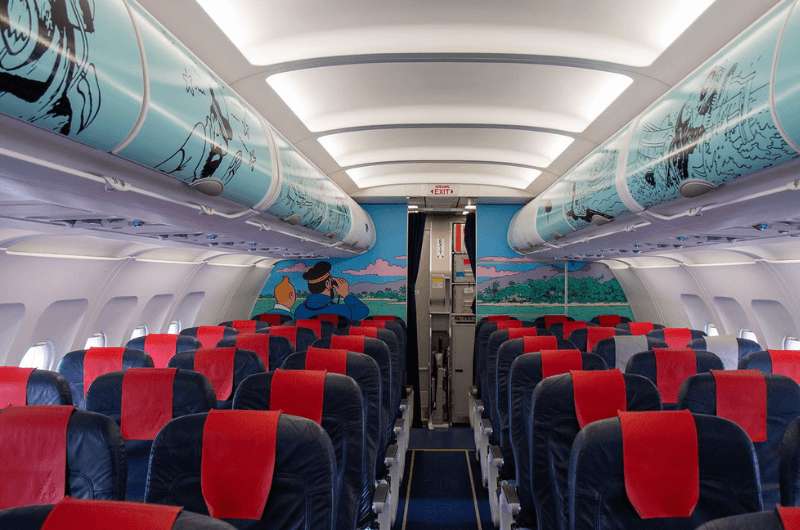 The interior of a Belgian Airlines airplane with Tintin comics in the design