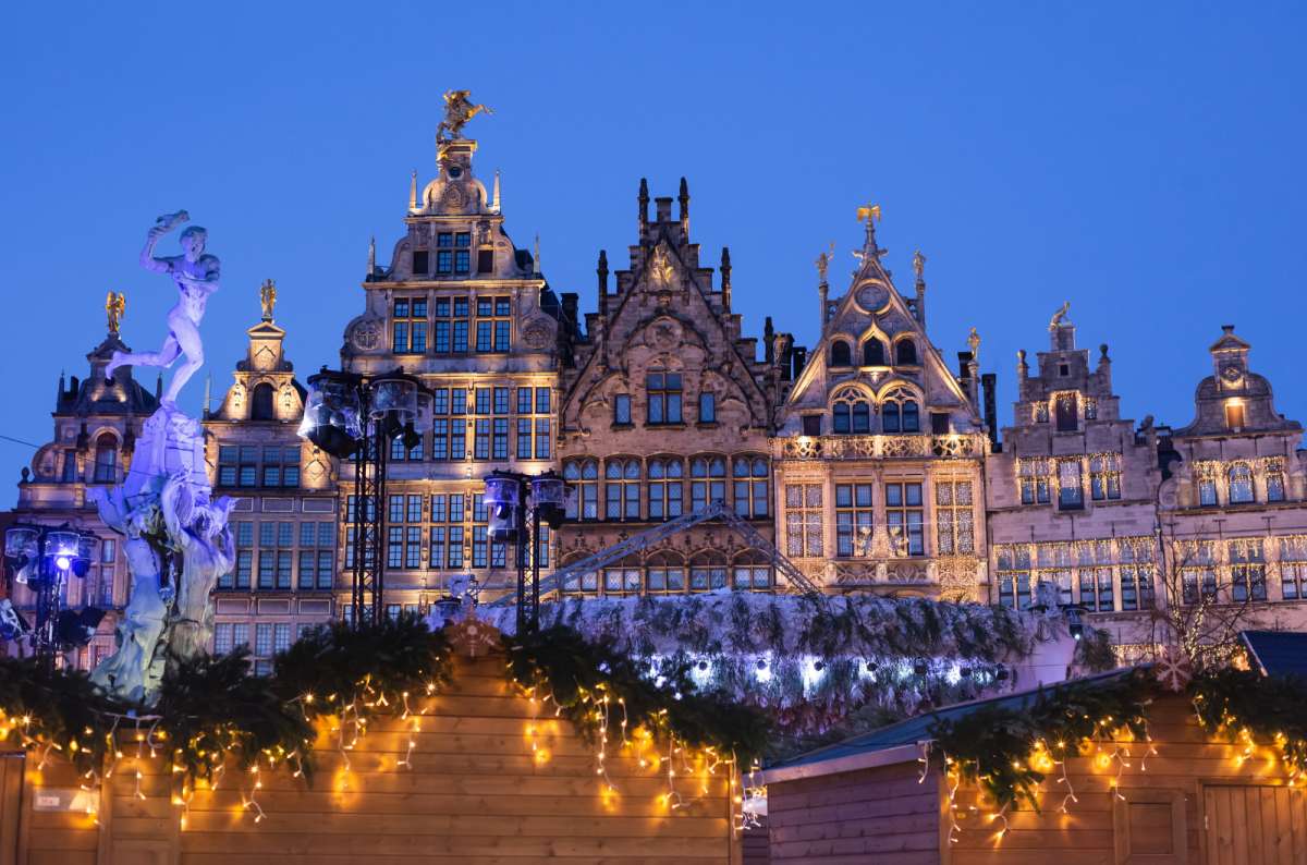 Illuminated historic guild houses and Brabo Fountain at the Grote Markt in Antwerp, Belgium during winter