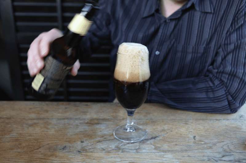 Pouring a glass of stout Belgian beer
