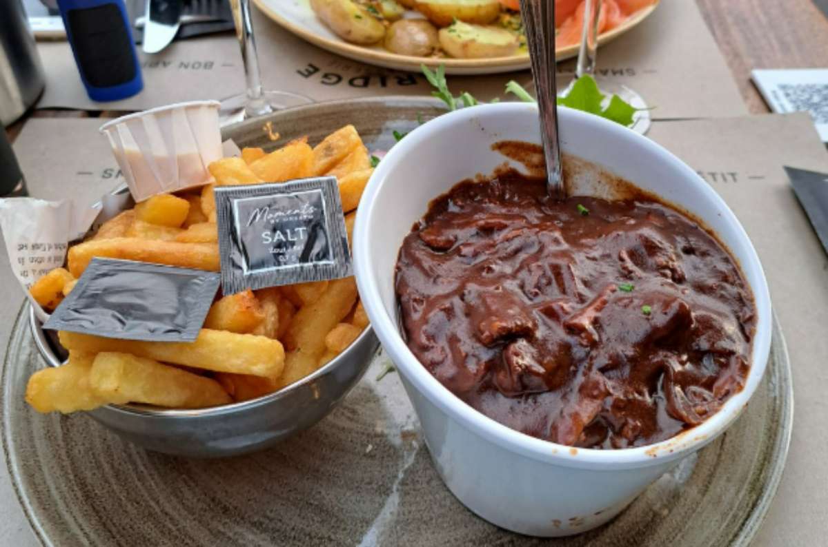 A bowl of Belgian beef stew with thick fries on the side, served at Bridge restaurant in Ghent, Belgium