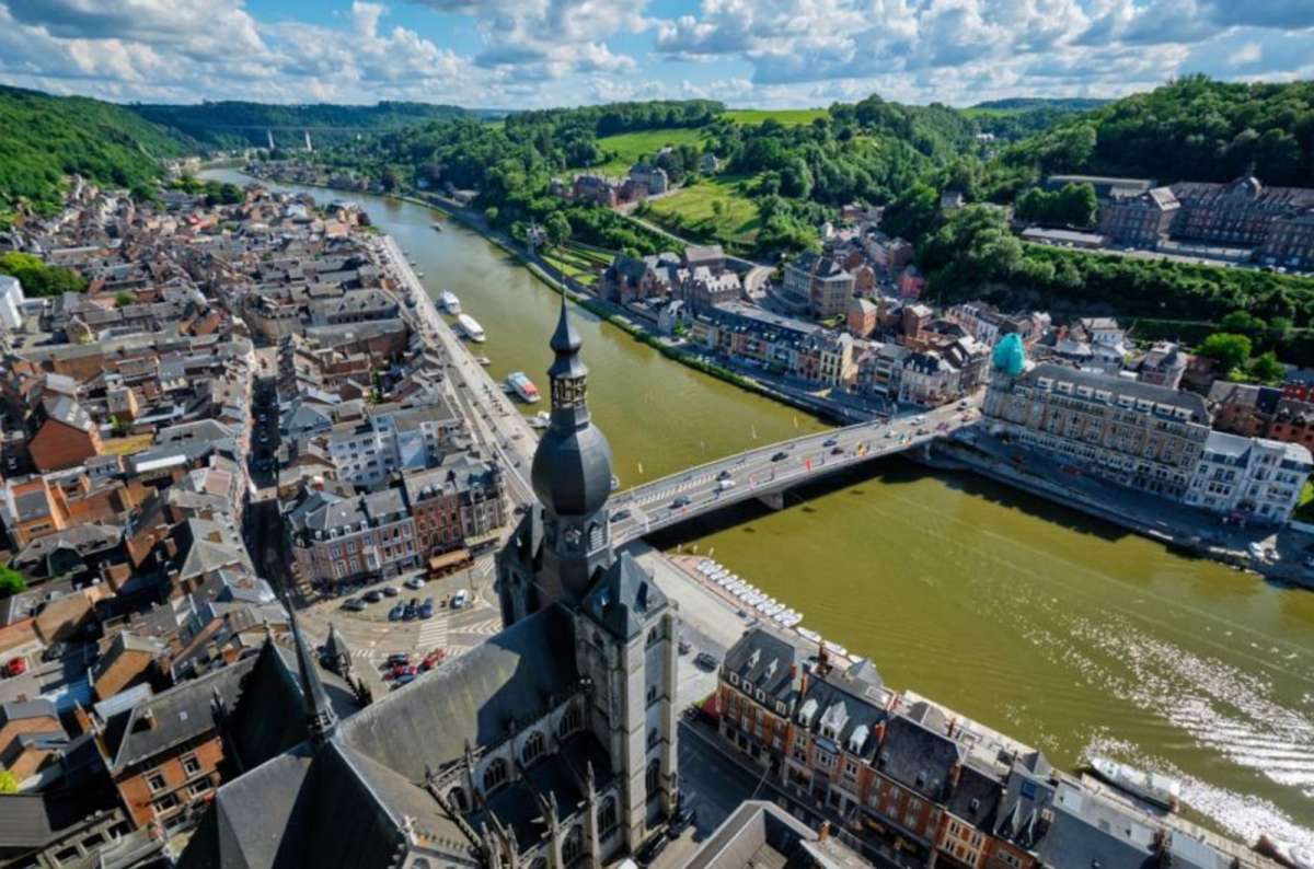 a photo of Dinant from above, with the Notre Dame de Dinant, river and the Charles de Gaulle Bridge visible, Dinant, Belgium