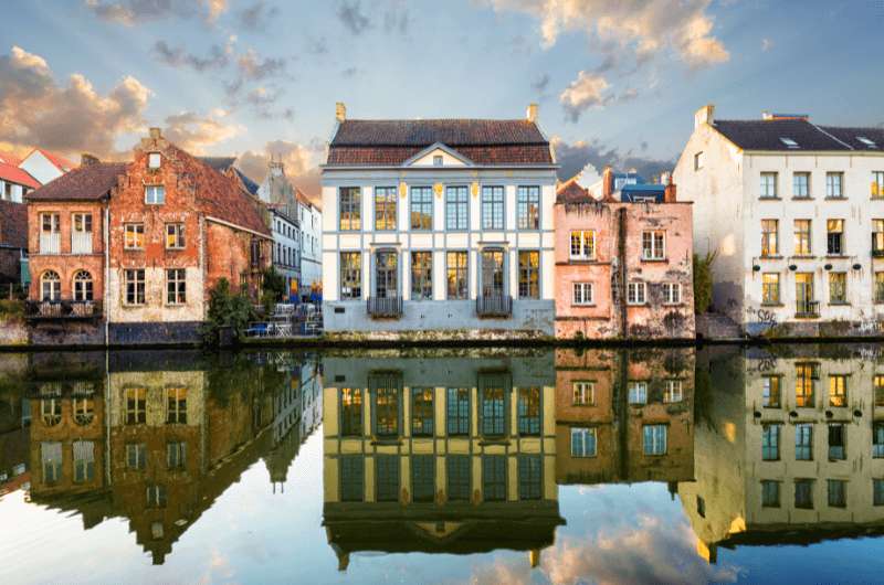 A view of the colorful buildings of Ghent reflected in the river