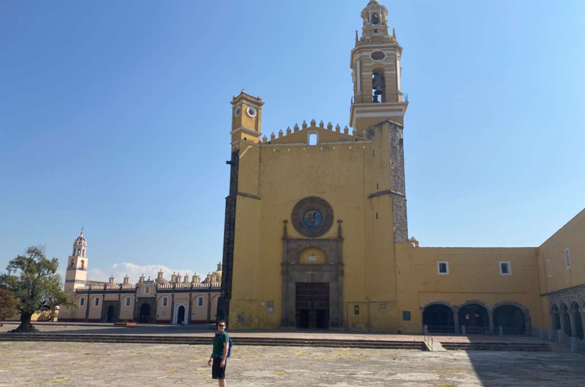a photo of a tourist standing in front of the Convent of San Gabriel in Cholula, Puebla, Mexico, photo by Next Level of Travel