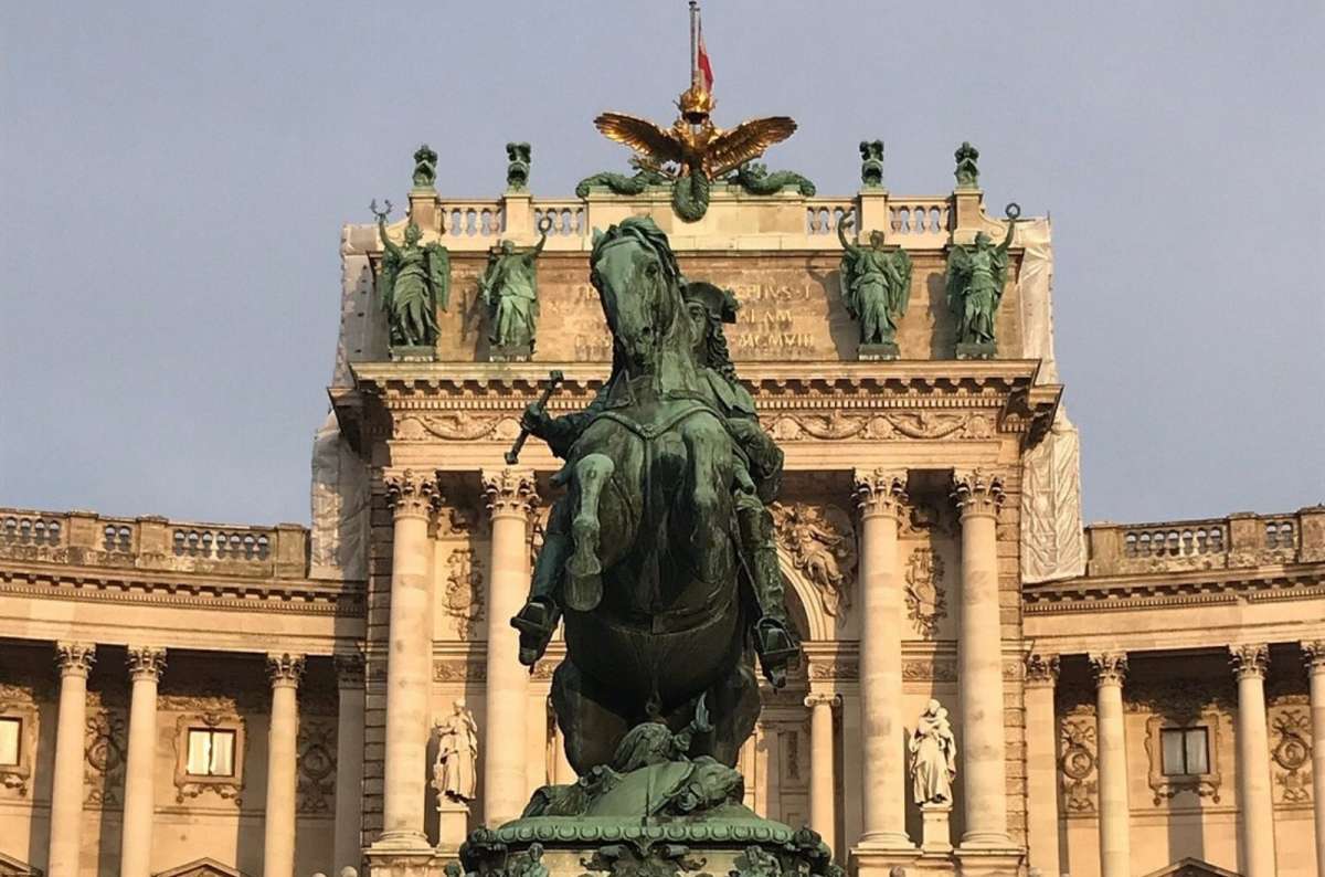 Equestrian statue at Hofburg Palace, visiting Vienna, Austria, with grand historic architecture in the background