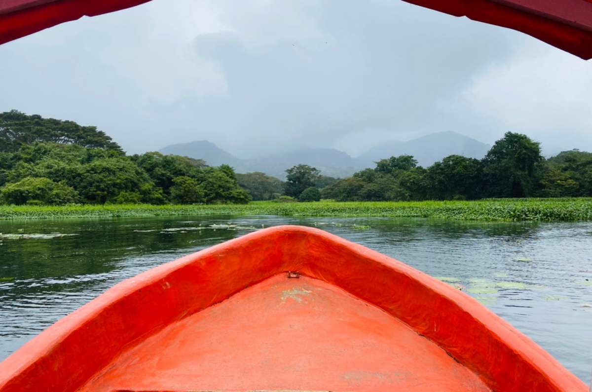 a photo of the view from the bow of a boat toward misty volcanic mountains across Laguna Catemaco, Catemaco, Veracruz, Mexico, photo by Next Level of Travel