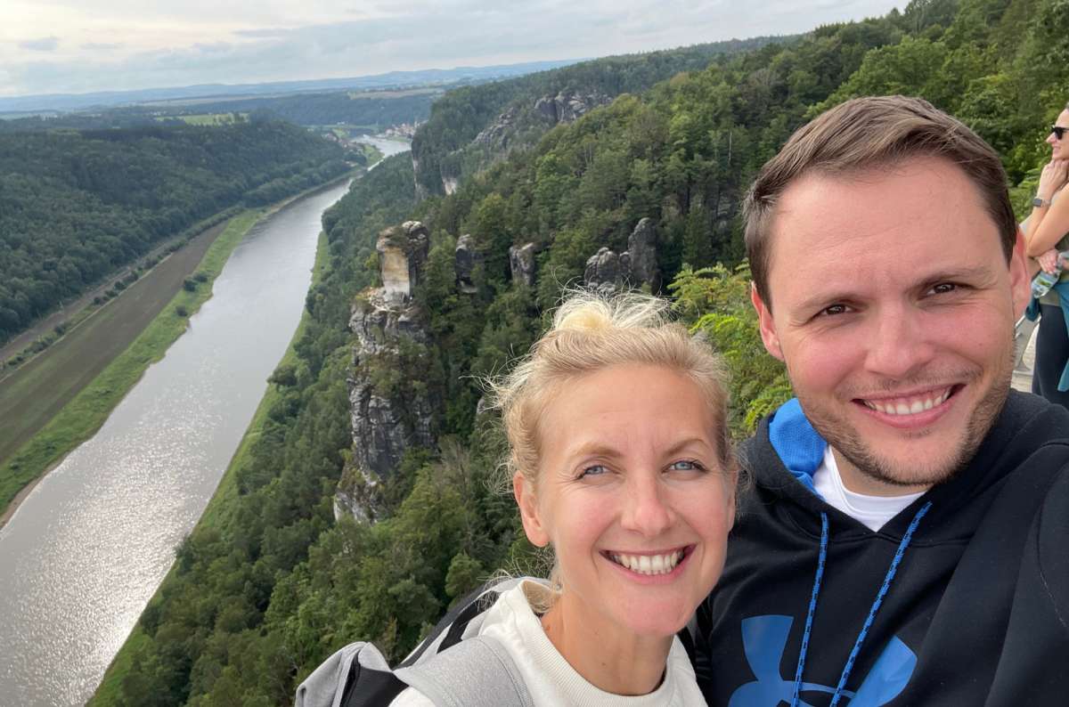A smiling couple takes a selfie at the Bastei Bridge viewpoint in Saxon Switzerland near Dresden, Germany, photo by Next Level of Travel