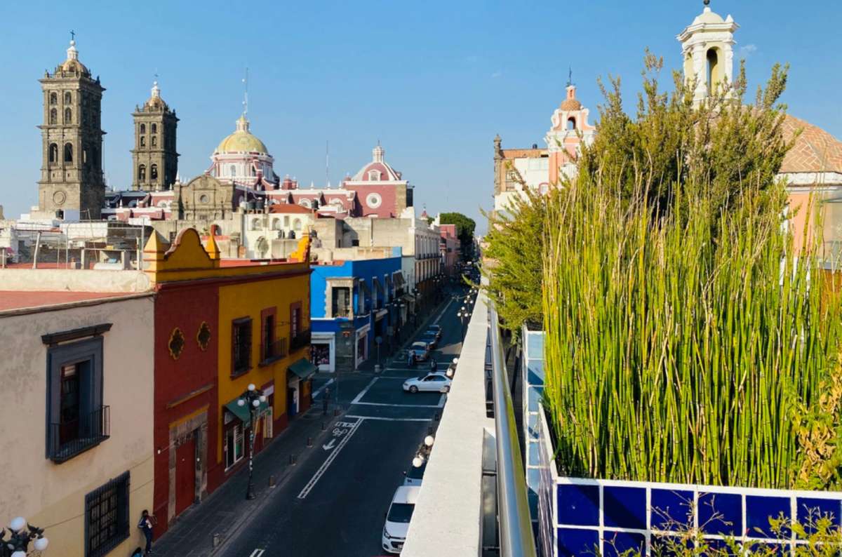 a photo of a rooftop terrace view over Puebla with the cathedral towers in the distance, Mexico, photo by Next Level of Travel