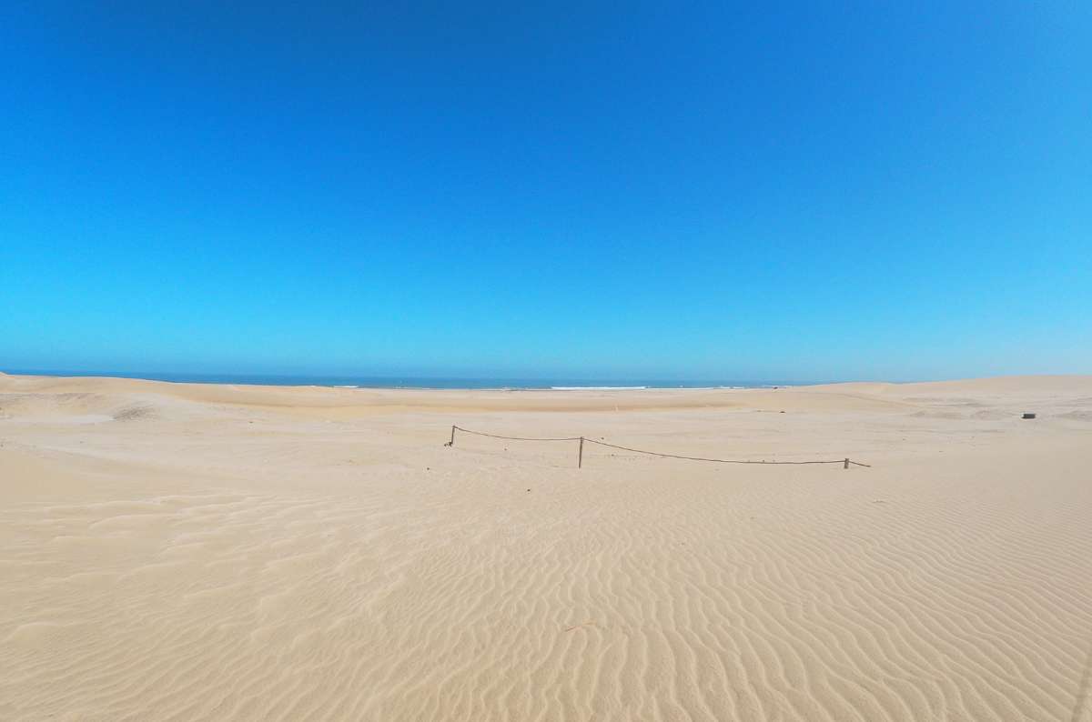 Skeleton Coast desert meeting the Atlantic Ocean, Namibia with sand dunes and empty shoreline, photo by Next Level of Travel 