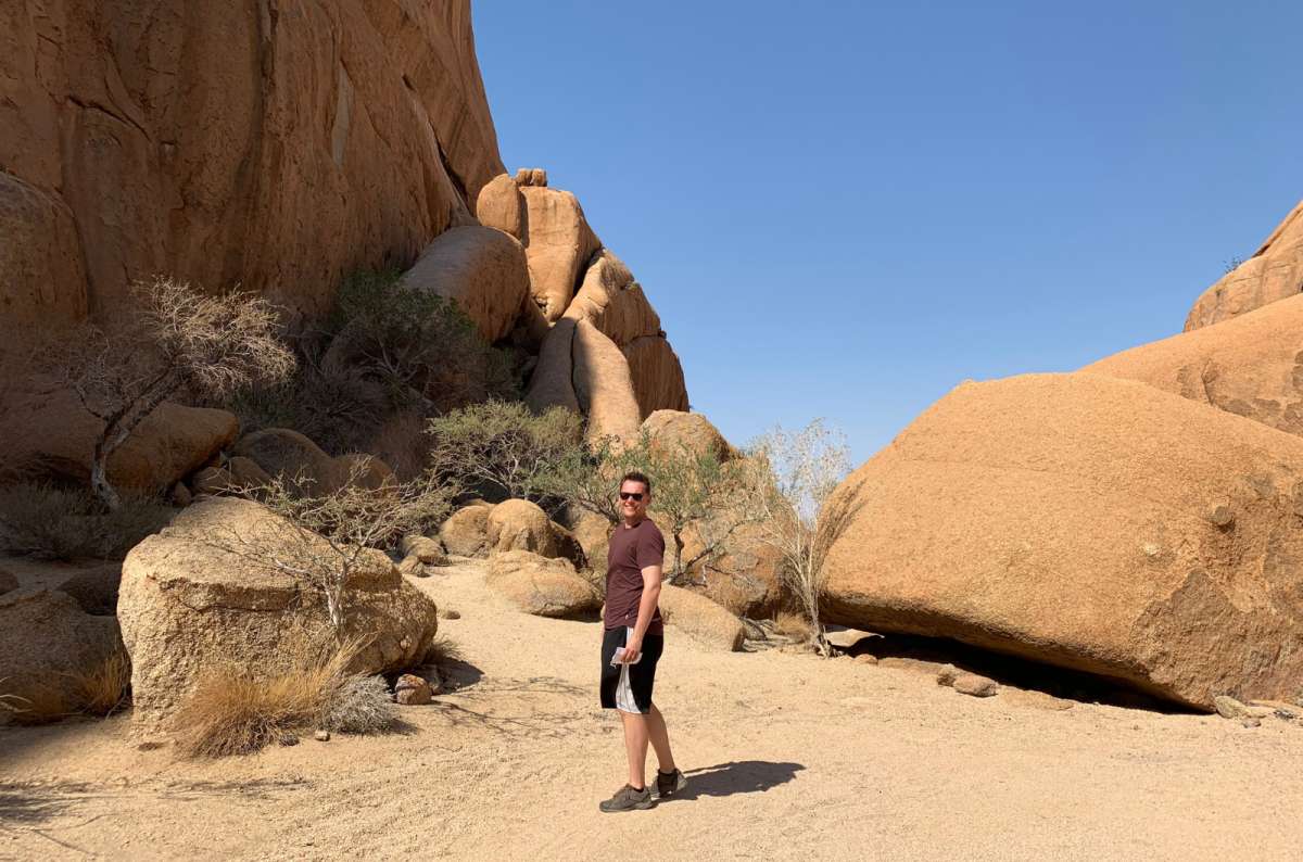a photo of a tourist posing in front of the Spitzkoppe, Namibia, photo by Next Level of Travel