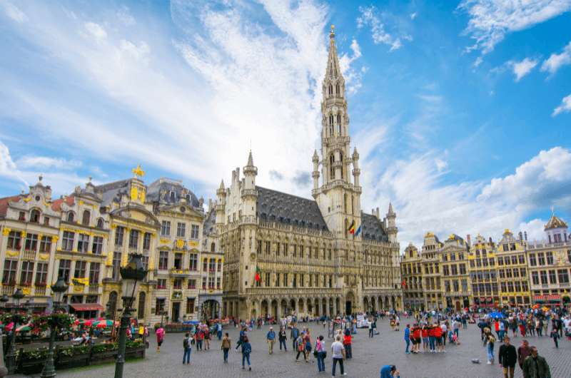 People walking around the busy Grand Place in Brussels, best place in Brussels