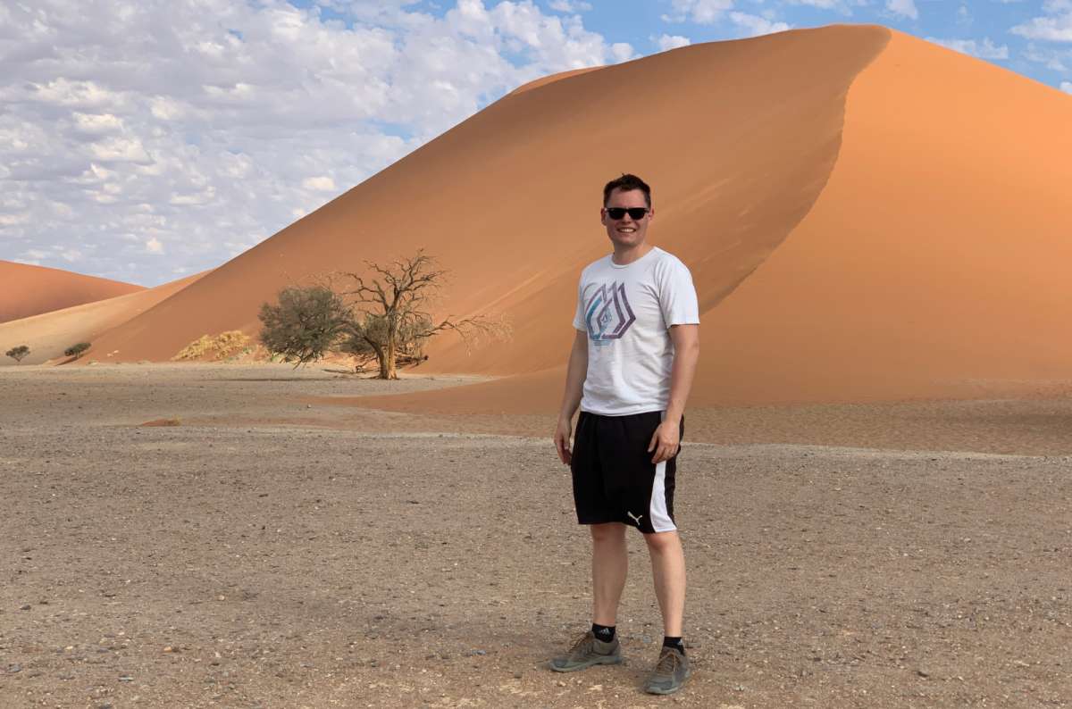 a photo of a tourist posing in front of one of the biggest dunes in the Namib Desert, the Big Daddy, Namibia, photo by Next Level of Travel