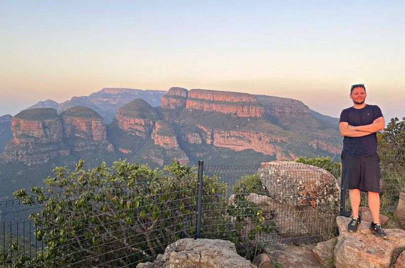 A tourist visiting Three Rondavels viewpoint at sunset, driving the Panorama Route in one day, South Africa travel
