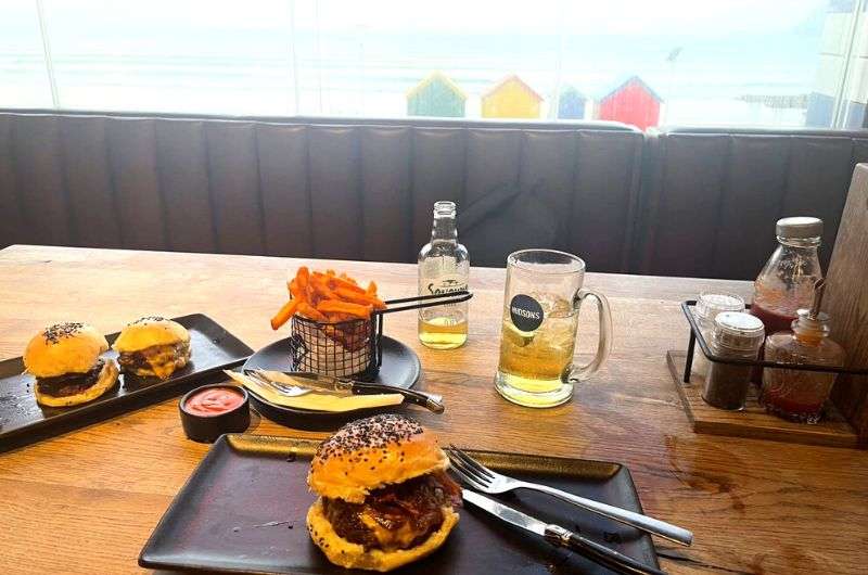 Having a burger and beer at Hudsons at Muizenberg Beach, dinner on day 3 of Cape Town itinerary