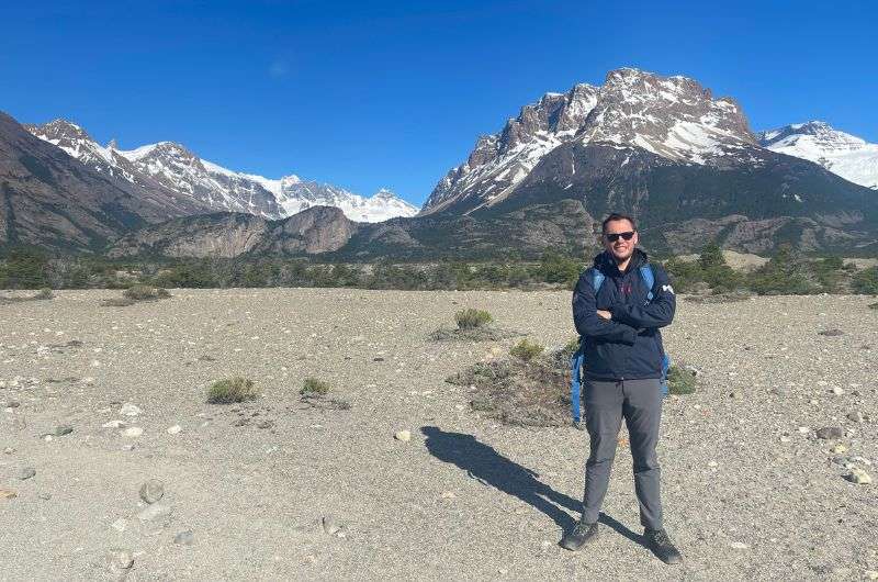 A tourist visiting Patagonia in Argentina, standing in front of the snow-capped mountains