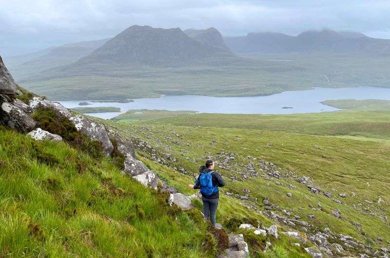 Tourist on a walking tour on Stac Pollaidh in Scotland, photo by Next Level of Travel