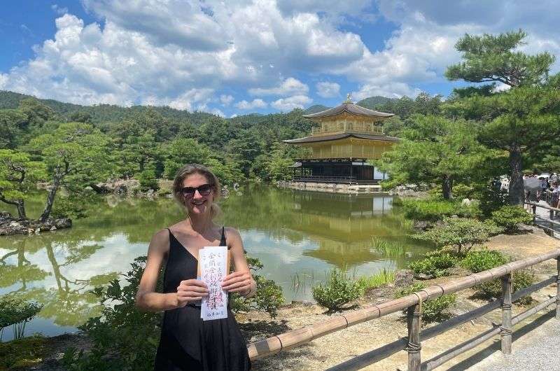 A traveler stands at a railing in front of a pond in Kyoto, Japan, Photo by Next Level of travel