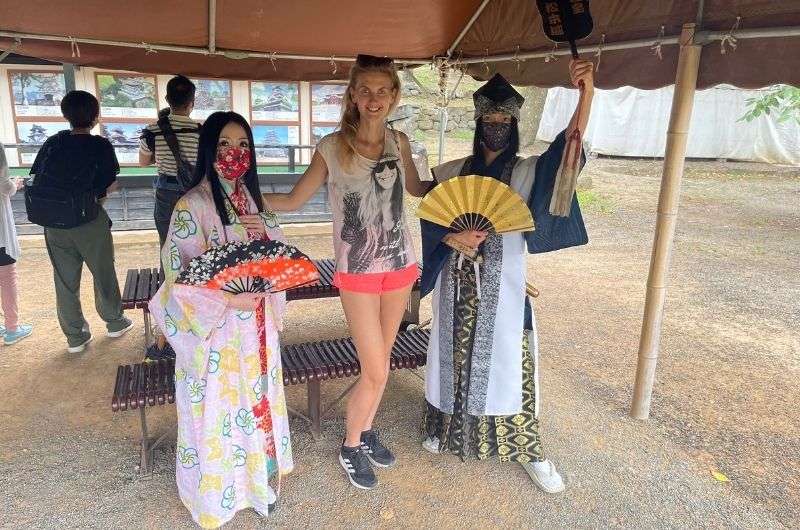 traveler posing with women in traditional Japanese clothing in Matsumoto Castle, Japan, photo by Next level of Travel