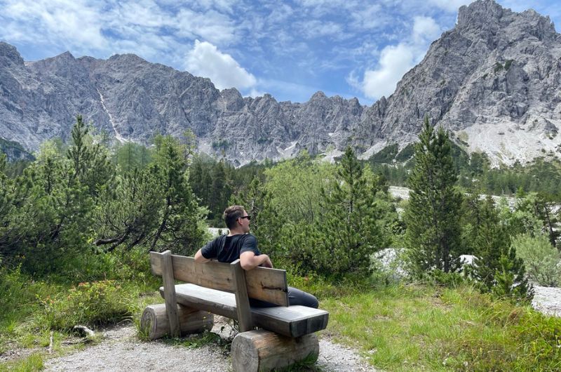Man sitting on a bench observing the mountains in Berchtesgaden on hike to Hitler’s Eagle’s Nest in Germany, photo by Next Level of Travel