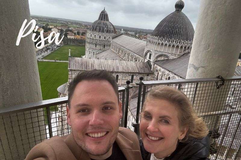 A couple enjoying the sights of Pisa, on the Leaning Tower with Piazza dei Miracoli in the background, Italy, photo by Next level of travel