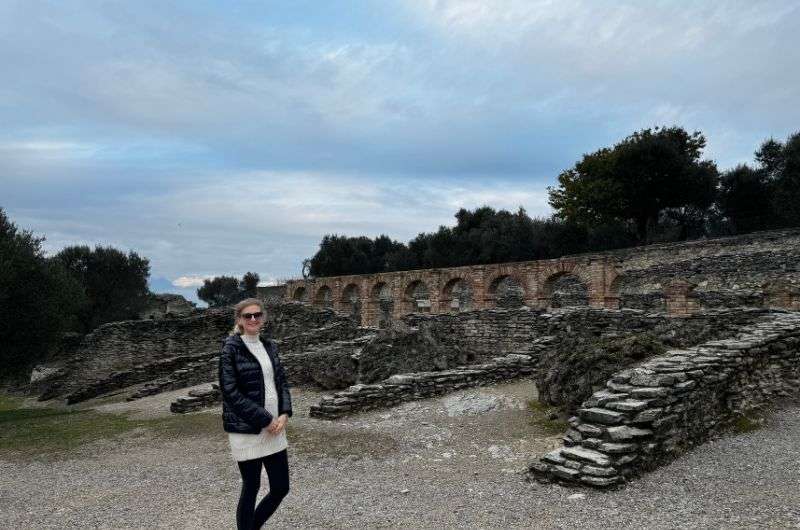 Female traveler in front the ruins of Terme di Catullo, visiting Sirmione, Italy, photo by Next level of travel