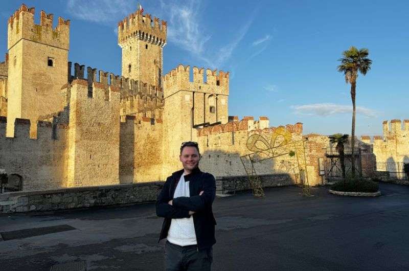 tourist in front of the Castello Scaligero, tourist attraction in Sirmione, Italy, photo by Next level of travel