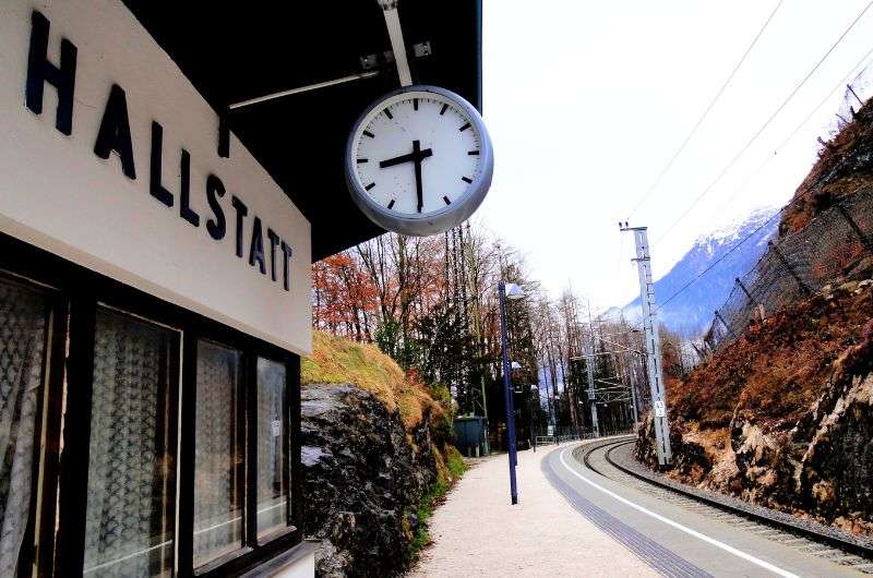 Hallstatt train station with clock and train tracks, arriving in Hallstatt for one day, Austria