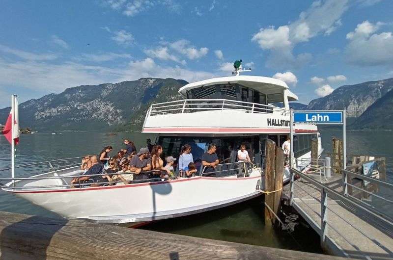 the Hallstatt ferry full of tourists at the port in Hallstatt, Austria