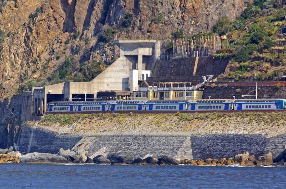 A regional train travels along the coast at the Corniglia station in Cinque Terre, Italy