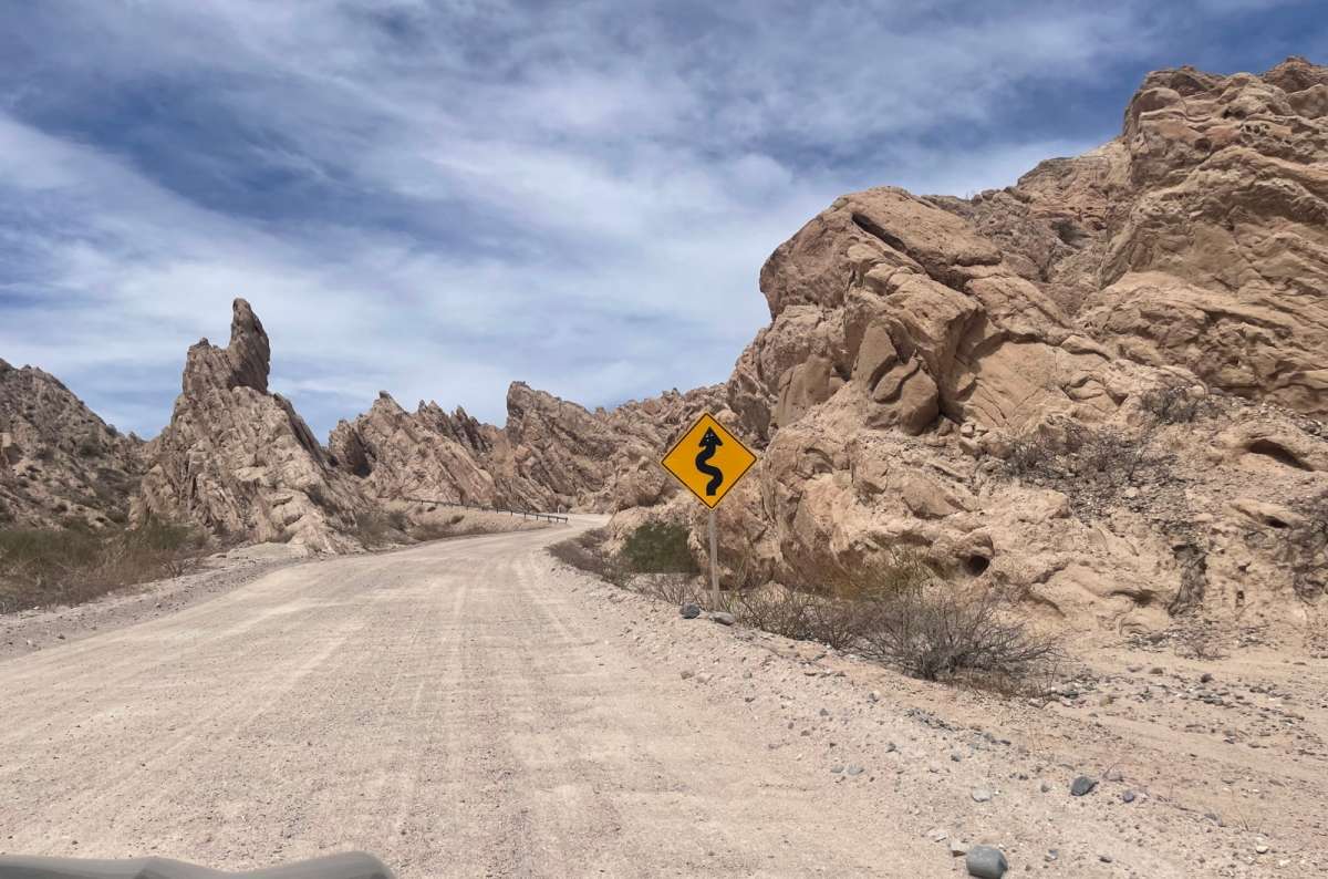 Dirt road and road sign in Quebrada de las Flechas, Argentina, photo by Next Level of Travel Caption: Quebrada de las Flechas