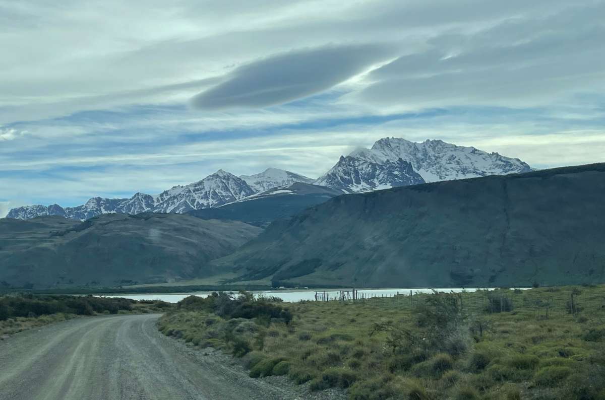 Snowy mountains and a lake in the background under a cloudy sky, Argentina, photo by Next Level of Travel