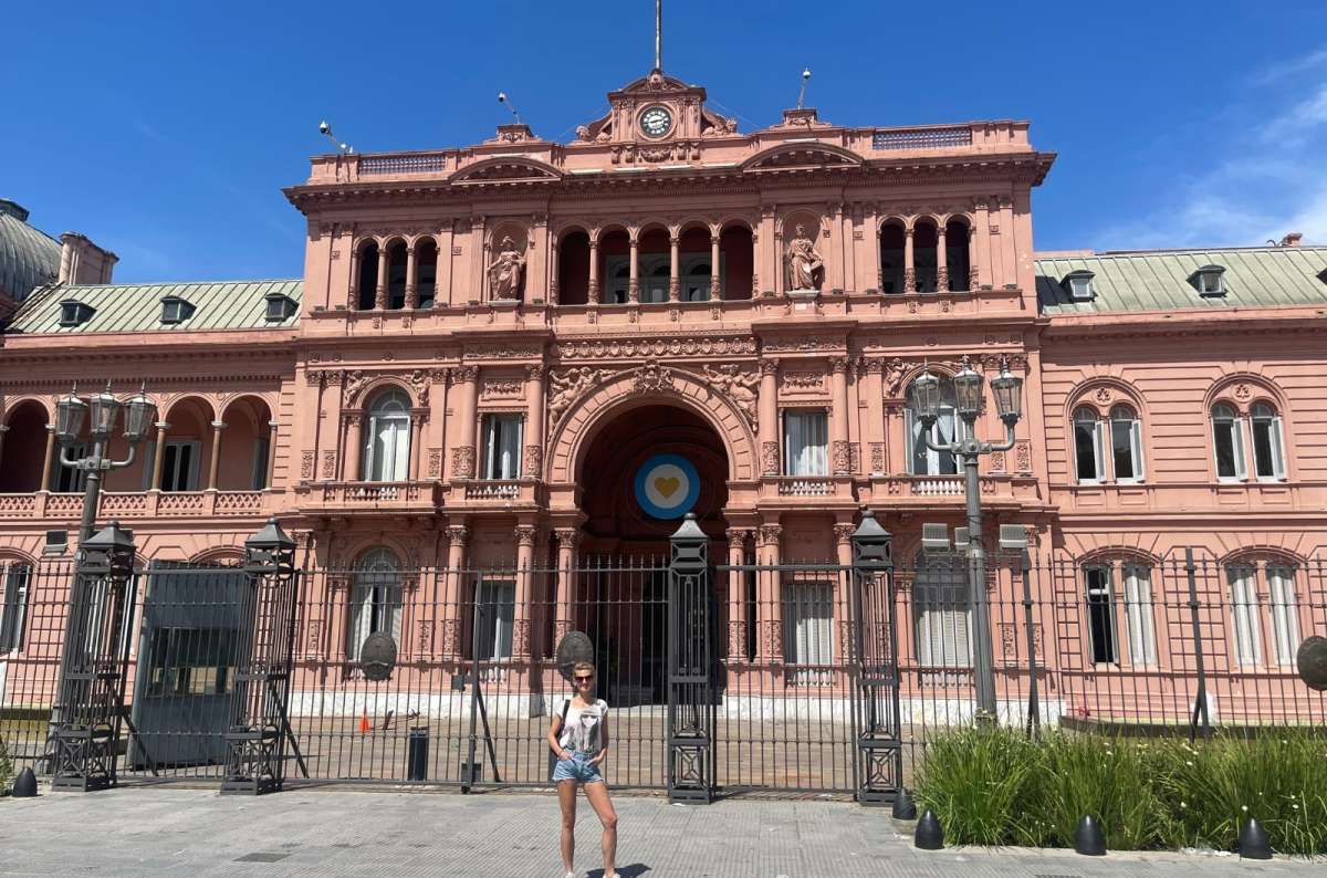 Tourist posing in front of the iconic pink façade of Casa Rosada, the presidential palace in Buenos Aires, Argentina itinerary, photo by Next Level of Travel