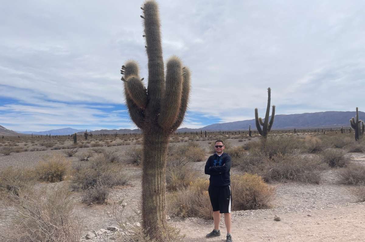 Tourist standing next to a tall cactus in Los Cardones National Park, Argentina, photo by Next Level of Travel
