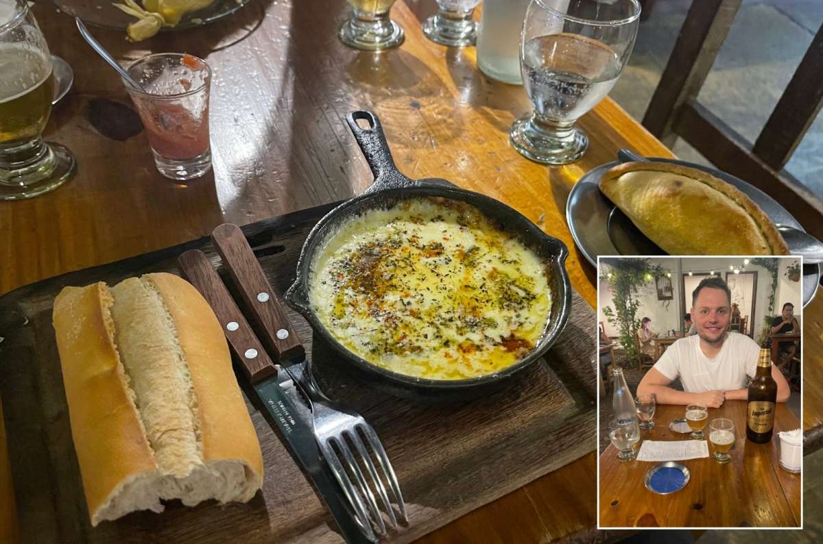 Traditional Argentine meal, melted cheese in a skillet with bread and drinks, photo by Next Level of Travel